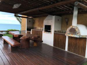 a wooden deck with a table and a stove at Casa Buena Vista in Arraial d'Ajuda