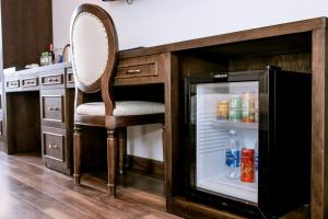 a refrigerator with a chair in a kitchen at Louisland Hanoi Hotel in Hanoi