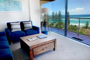 a living room with a blue couch and a coffee table at Waterview Resort in Caloundra