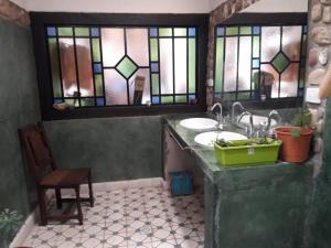 ein Badezimmer mit einem Waschbecken und Buntglasfenstern in der Unterkunft Lo de Joaquin in Tilcara