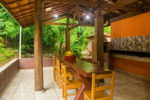un patio al aire libre con mesa de madera y sillas en Cantinho na roca 2, en Santo Antônio do Pinhal