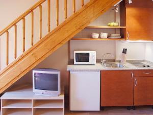 a kitchen with a counter with a microwave and a tv at Aparthotel Nou Vielha in Vielha