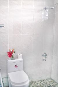 a bathroom with a toilet with flowers on top of it at Pacific Paradise Motel in Port Vila