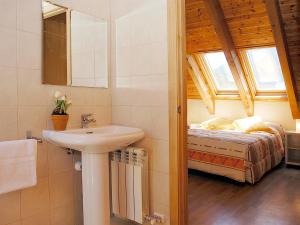 a bathroom with a sink and a bed at Aparthotel Nou Vielha in Vielha