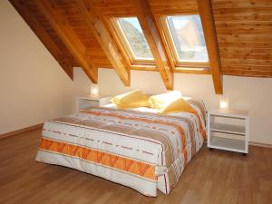 a bedroom with a large bed with two windows at Aparthotel Nou Vielha in Vielha