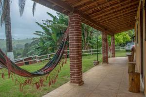 a hammock hanging from a porch with a view at Cantinho na Roça in Santo Antônio do Pinhal