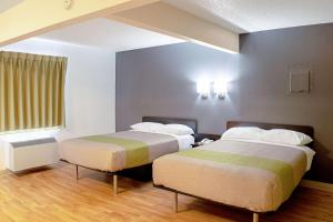 Un pat sau paturi într-o cameră la Welcome Suites Springdale