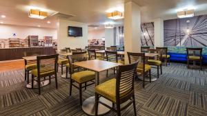 un restaurante con mesas, sillas y TV en Best Western Yacht Harbor Hotel en San Diego