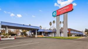 サクラメントにあるSureStay Plus Hotel by Best Western Sacramento Cal Expoの駐車場の看板付きガソリンスタンド
