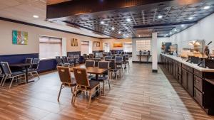 uma sala de jantar com mesas e cadeiras e um bar em SureStay Plus Hotel by Best Western Sacramento Cal Expo em Sacramento