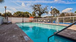 een zwembad in een resort met een wit hek bij Best Western Plus Chain of Lakes Inn & Suites in Leesburg