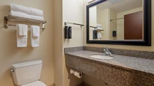 a bathroom with a toilet, sink and mirror at Best Western Plus Chain of Lakes Inn & Suites in Leesburg