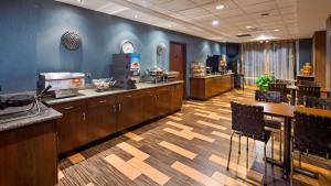 a kitchen with a stove, a sink, and a counter top at Best Western Plus Chain of Lakes Inn & Suites in Leesburg