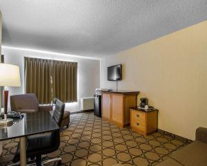 a hotel room with a desk and a living room at Comfort Inn Regina East in Regina