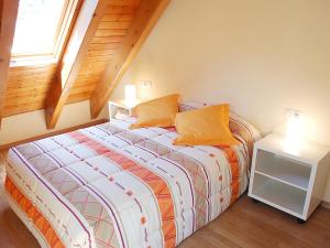 a bedroom with a bed with orange pillows and a window at Aparthotel Nou Vielha in Vielha