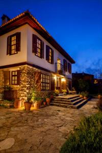 a large white house with stairs and a patio at Gullu Konaklari in Selçuk