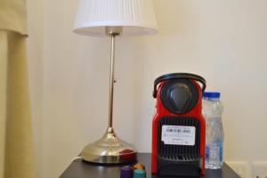 una mesa con una lámpara y un aparato rojo. en 151 en Kuwait