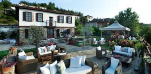 a garden with chairs and a gazebo in front of a house at Gullu Konaklari in Selcuk