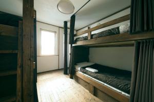 小樽市にあるOtaru Tap Room & Hostelの二段ベッド2台と窓が備わる客室です。