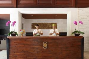 沙努爾的住宿－格萊亞桑川海灘度假酒店，两个人手臂交叉站在柜台