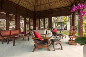 a living room filled with furniture and a large window at Griya Santrian a Beach Resort in Sanur