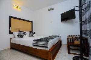 une chambre avec un lit et une télévision à écran plat dans l'établissement Vendol Sky Resort, à Kandy