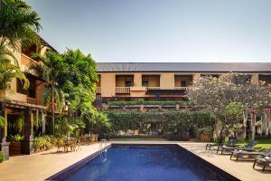 a swimming pool in front of a building with a resort at Holiday Garden Hotel & Resort SHA EXTRA PLUS in Chiang Mai