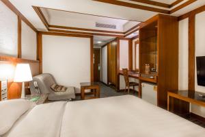 um quarto de hotel com uma cama e uma secretária em Kingshi Hotel Taipei em Taipei
