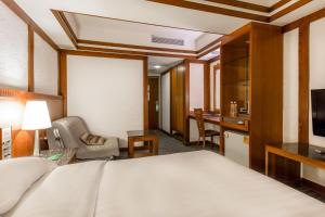 a hotel room with a bed and a desk at Kingshi Hotel Taipei in Taipei