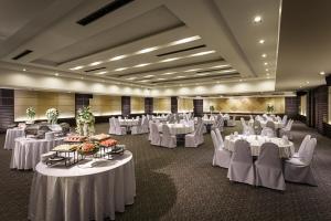 a banquet hall with white tables and white chairs at Holiday Garden Hotel & Resort SHA EXTRA PLUS in Chiang Mai