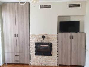 a living room with a brick fireplace with a tv at Kalina apartment in Ruse