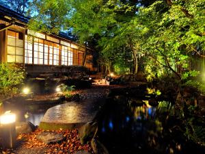 a garden with a pond in front of a building at Heihachi Tea House Inn in Kyoto