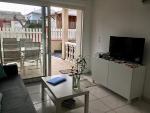 a living room with a television and a table at La Belle Gruissanaise in Gruissan