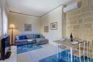 a living room with a couch and a table at Traditional Maltese Townhouse, Roof Terrace and Views in Senglea