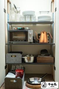a kitchen pantry with dishes and a toaster oven at Konjaku-So Osaka Castle South in Osaka