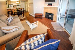 a living room with a couch and a fireplace at Harbor Village Pool Building Condo 107 in Garden City