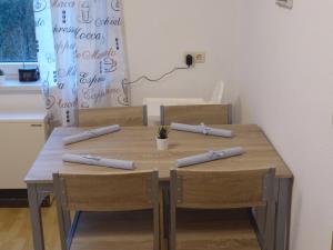 een houten tafel met vier stoelen en een bord aan de muur bij Ferienwohnung zum Pinguin in Wiednitz