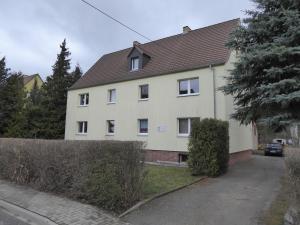 une maison blanche avec un toit marron dans l'établissement Ferienwohnung zum Pinguin, à Wiednitz