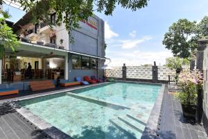 a large swimming pool in front of a building at RedDoorz Plus near Mall Bali Galeria 2 in Denpasar
