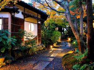 a stone path next to a house with lights on it at Heihachi Tea House Inn in Kyoto