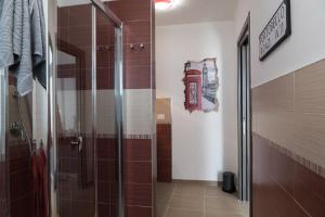 a bathroom with a glass shower with a phone booth on the wall at Coco'S Rooms in Bari Palese +37 photos
