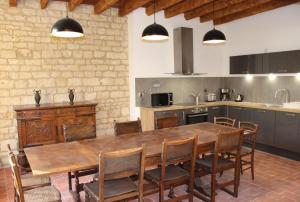 une cuisine avec une grande table et des chaises en bois dans l'établissement Château des Loups - Les Pommiers, à Échiré