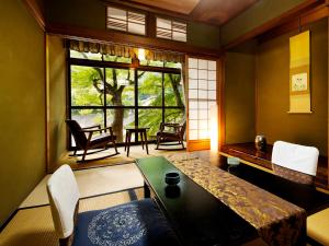a room with a table and chairs and a window at Heihachi Tea House Inn in Kyoto