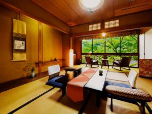 a living room with a table and chairs and a large window at Heihachi Tea House Inn in Kyoto +34 photos