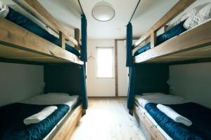 two bunk beds in a room with a window at Otaru Tap Room & Hostel in Otaru