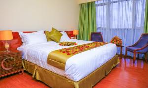 Un dormitorio con una cama grande con flores. en Denver boutique hotel en Addis Abeba