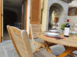 una mesa de madera con una botella de vino y 2 sillas en Il Torchio, en Musso