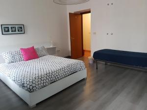 a bedroom with a bed with a pink pillow at B&B Porto Vecchio ROOMS - Stazione Centrale Trieste in Trieste