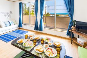 una mesa con platos de comida en la sala de estar en BBQ可能1棟まるまる貸し切り 最大12名 家族 友人でゆっくりすごせます Morley1, en Kin