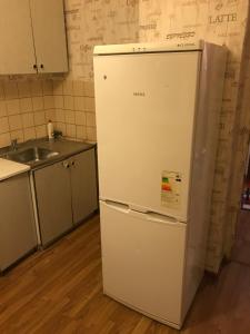 a white refrigerator in a kitchen next to a sink at Apartment G-Kvartal Planernaya 7k4 in Moscow